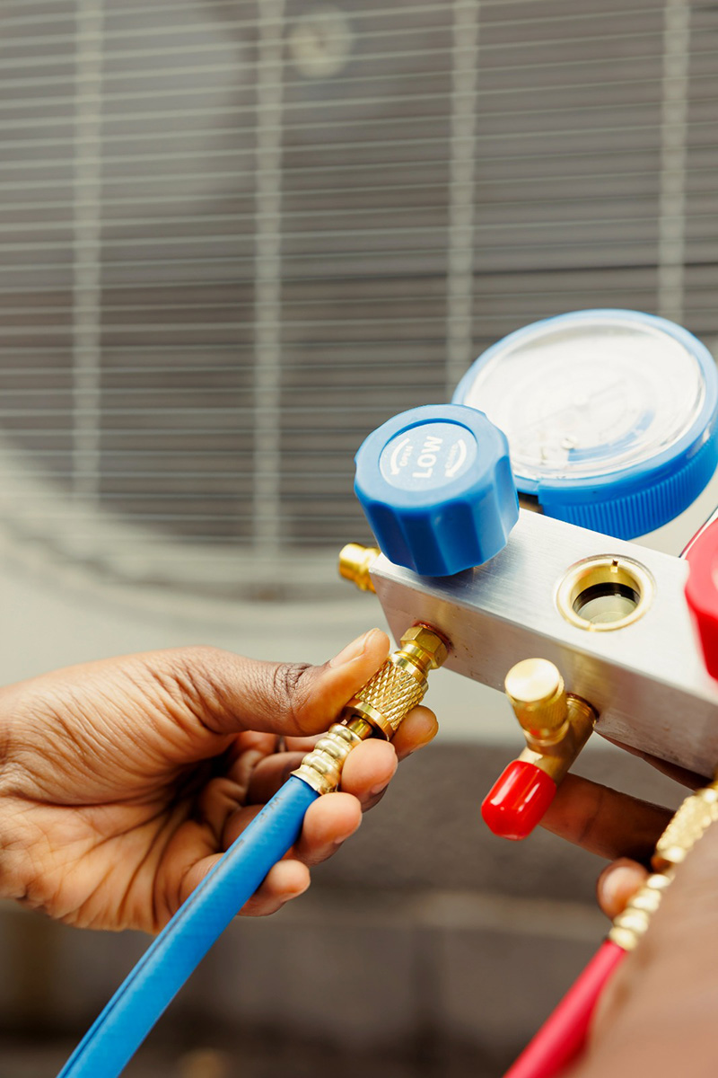Técnico conectando manômetros de refrigeração em equipamento